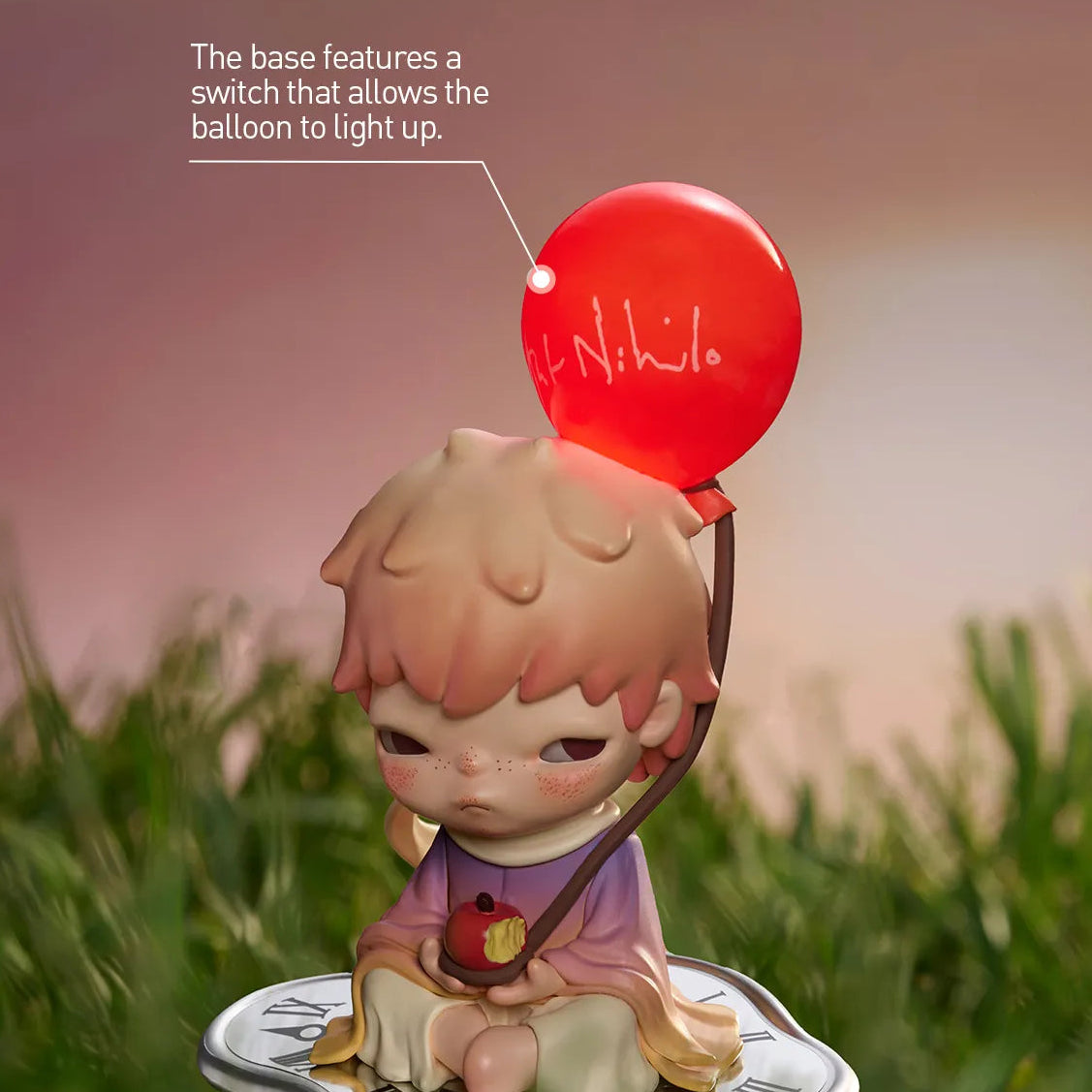 Figurine with a red balloon featuring a switch on a grassy background