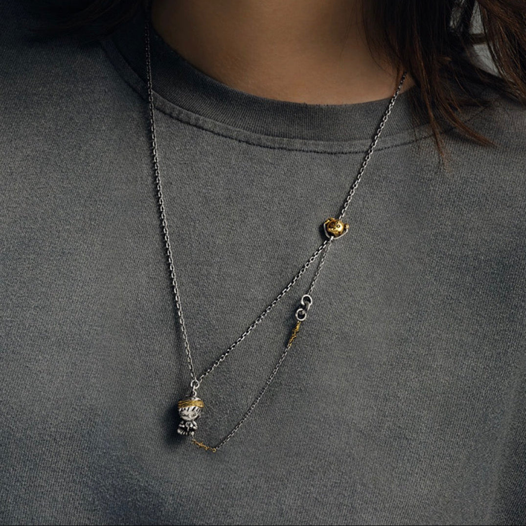 Necklace with small pendants on a gray shirt