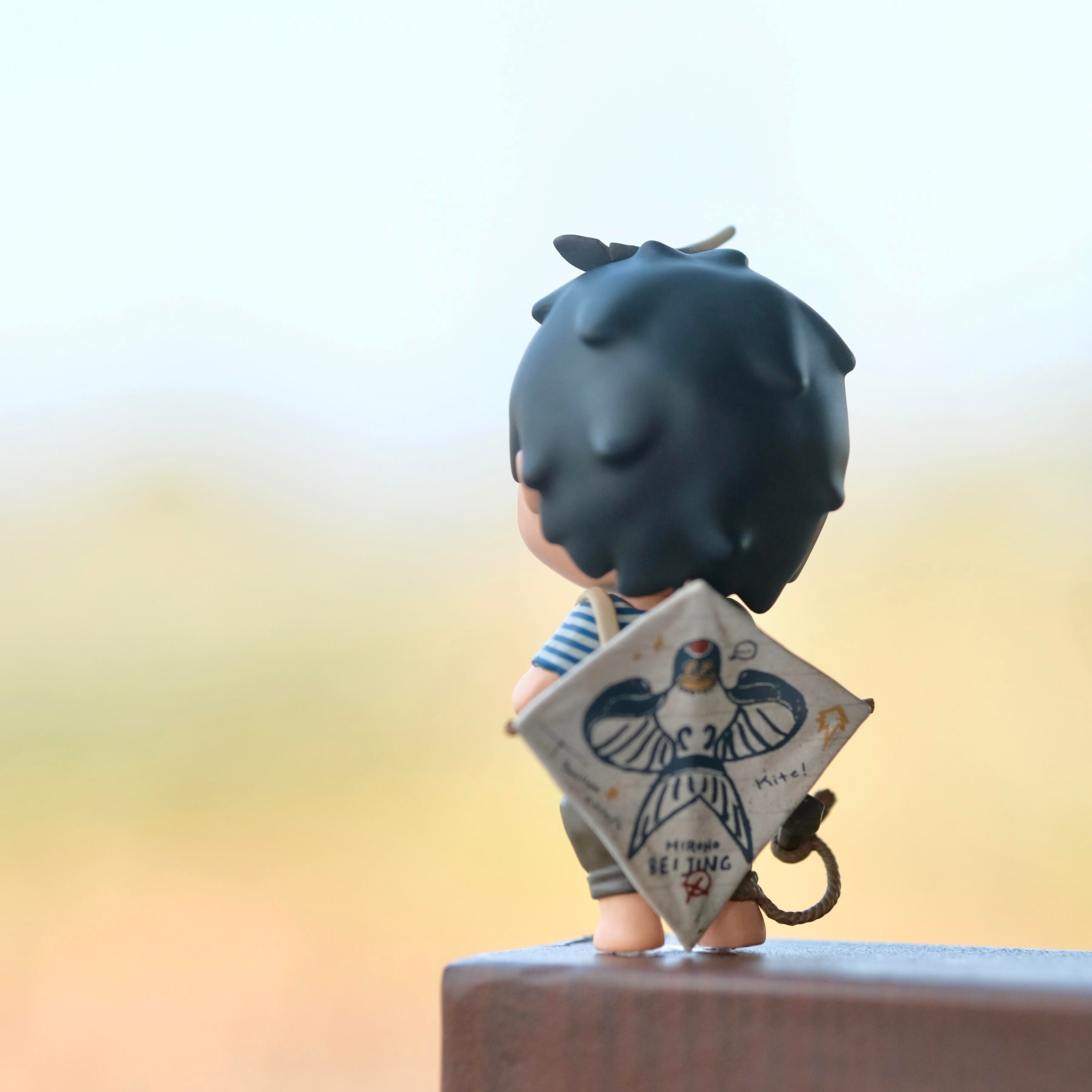 Hirono Kite Beijing Swift Figurine holding a book with a blurred background