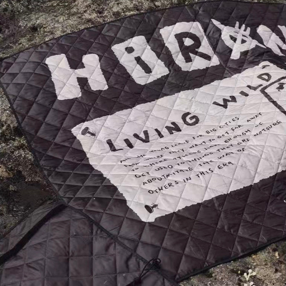 Quilt with text and logo on a stone surface