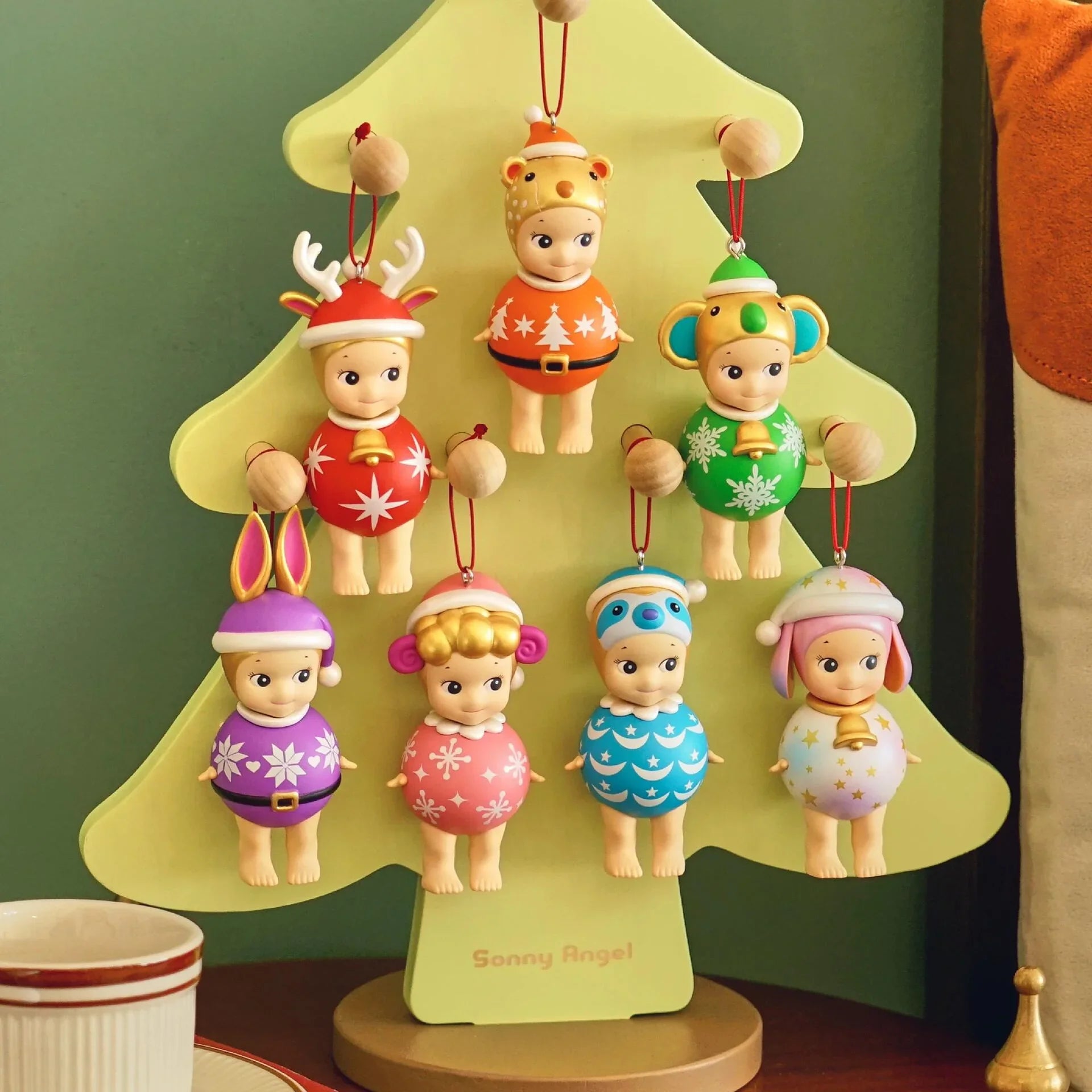 Decorative sonny angel Christmas tree with small figurines on a green background