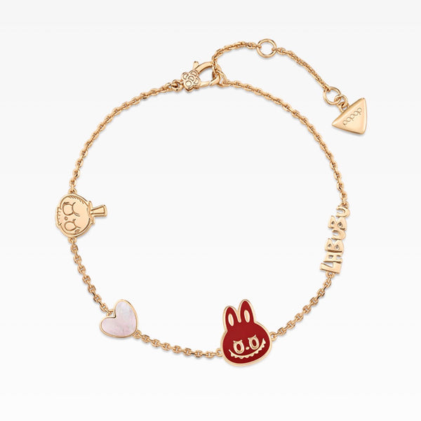 A gold chain bracelet featuring multiple charms, including a red rabbit head, a pale pink heart, a small gold heart, and a vertical gold 'LOVE' charm, displayed on a clean white background.
