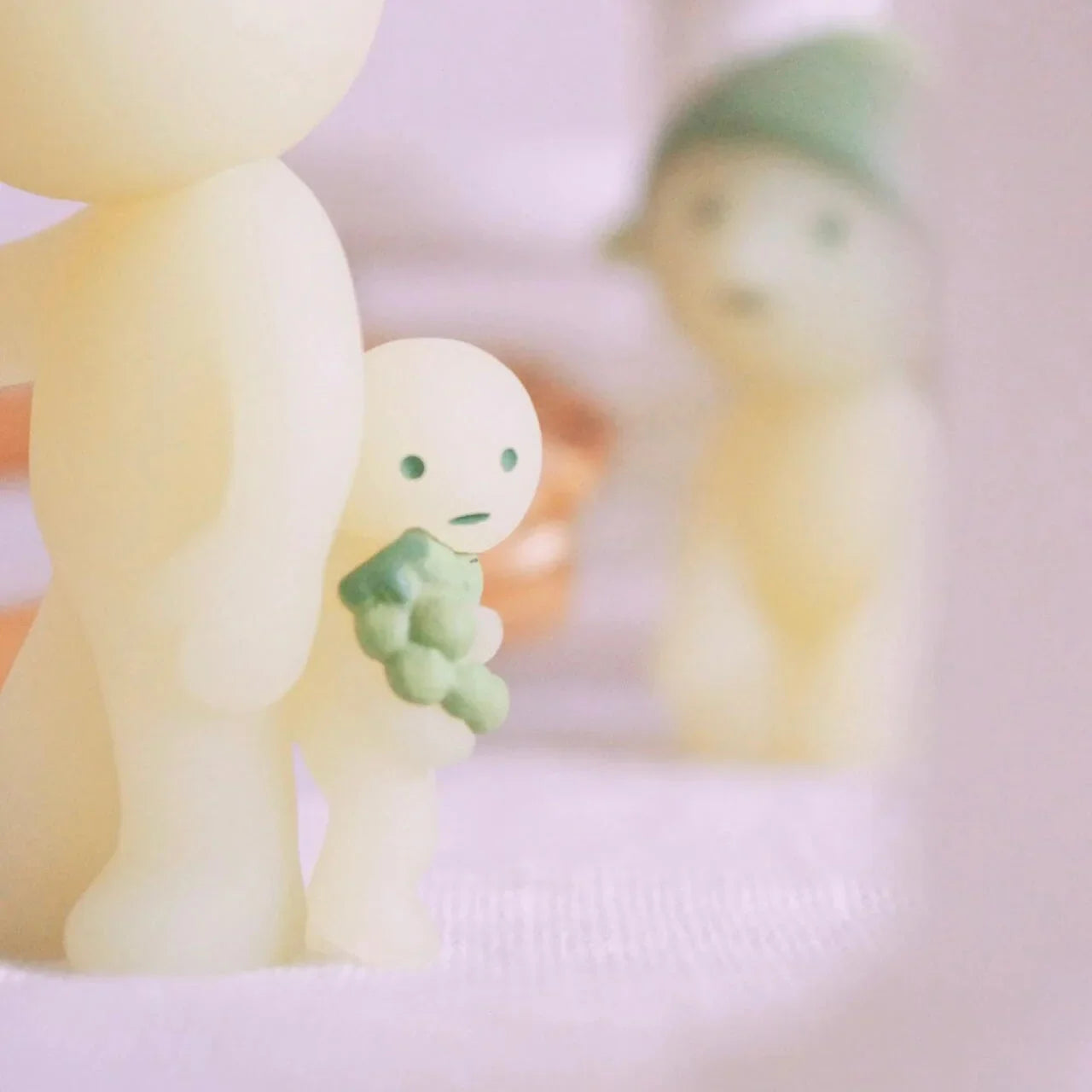 Small figurine holding a green object with a blurred background