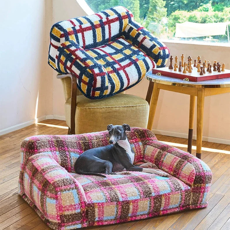 Colorful checkered pet bed with a dog lying on it in a room with a round window.