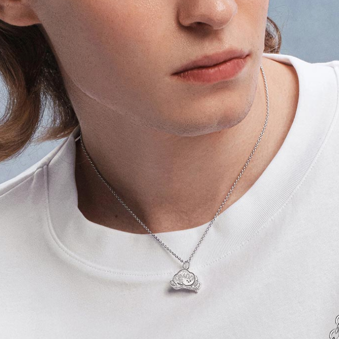 Close-up of a person wearing a POPOP Dimoo Cloud Song Shell Dreamland Necklace on a plain background