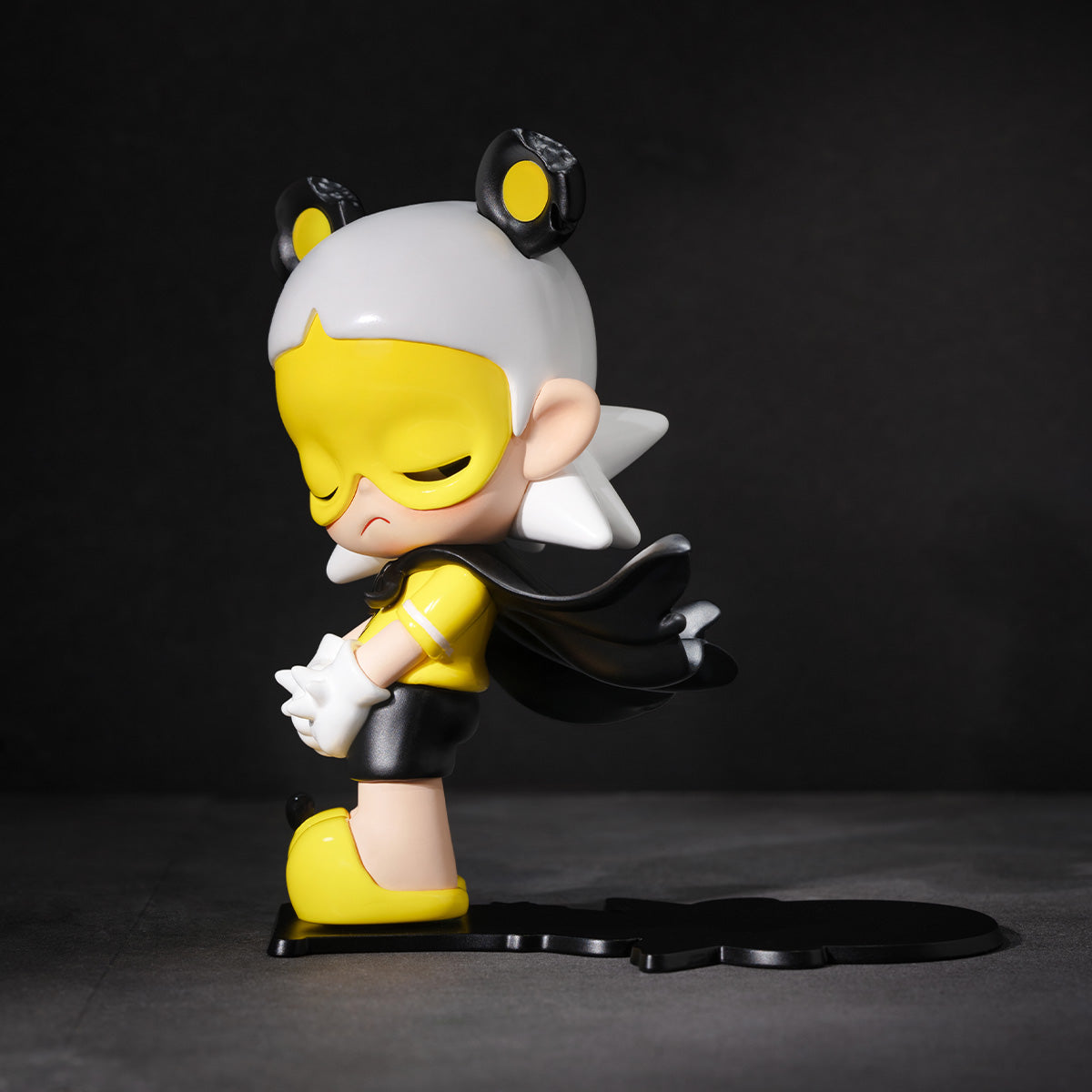 Zsiga Guard Figure with yellow face and black hair on a dark background
