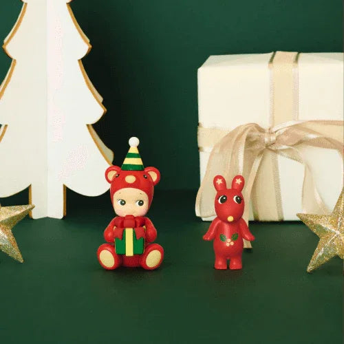 Two sets of Christmas-themed figurines and presents on a green and red background.