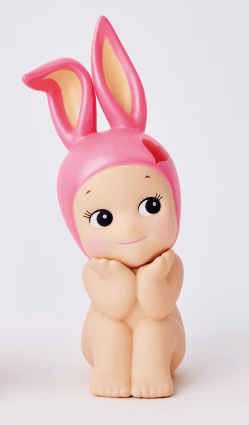 Toy figure of a baby with pink bunny ears on a white background