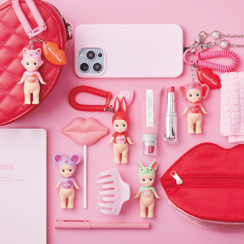 Pink-themed accessories including a phone case, lip gloss, and small figures on a pink background.