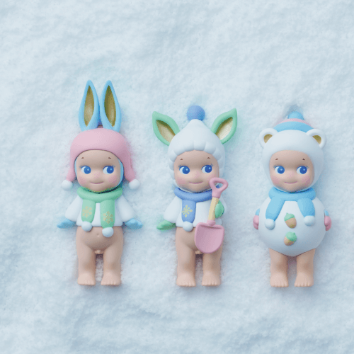 Six small figurines wearing colorful hats and outfits on a textured white background