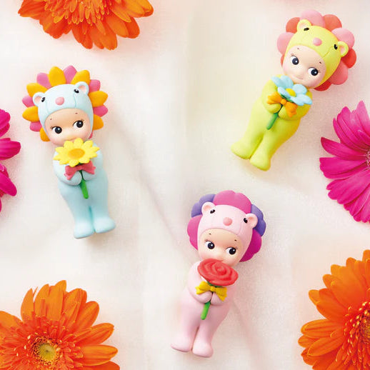 Colorful toy figures with flowers surrounded by bright flowers on a white background