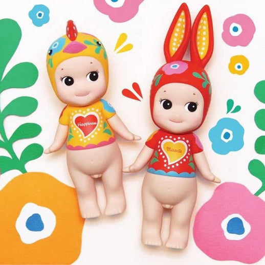 Two colorful dolls with animal ears on a floral background